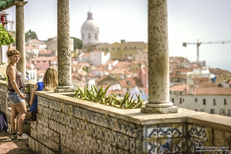 View from Miradouro de Santa Luzia with its tiled columns and the Pantheon dome in the distance, Alfama, Lisbon.